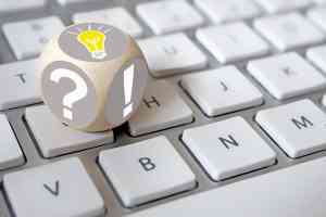 Würfel auf Tastatur mit Rufzeichen und Fragezeichen