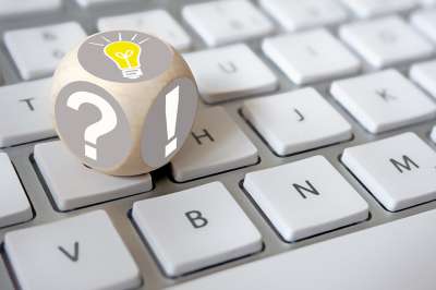 Würfel auf Tastatur mit Rufzeichen und Fragezeichen