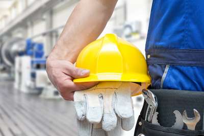 Gelber Arbeitshelm und Handschuhe